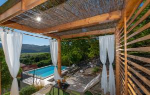 an outdoor patio with a pergola and a pool at Villa Pave-Makarska by Villas Guide in Juričići