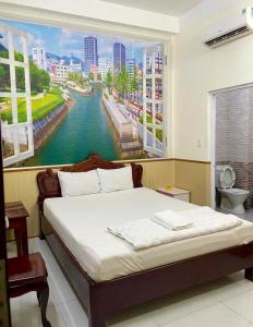 una camera da letto con un grande dipinto di un fiume di Nhà Nghỉ Kim Phượng Vũng Tàu a Vung Tau