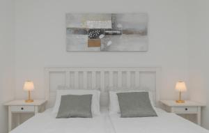 a bedroom with a white bed with two tables and two lamps at Villa Pave-Makarska by Villas Guide in Juričići +30 photos
