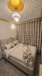a bedroom with a bed and a ceiling with a light at Stylish Studio Retreat- Inside Kunste Hotel in Nakuru
