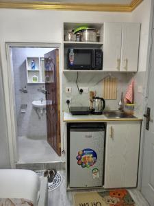 a small kitchen with a sink and a microwave at Stylish Studio Retreat- Inside Kunste Hotel in Nakuru
