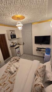 a bedroom with a large bed and a kitchen at Stylish Studio Retreat- Inside Kunste Hotel in Nakuru