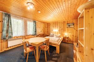 una stanza con un letto, un tavolo e delle sedie di Bungalow 13 - Finnhütte a Quitzdorf