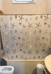 a bathroom with a shower curtain with starfish at N67 B&B Taranto Centro-3 camere indipendenti in Taranto