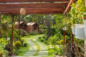 a garden with a walkway in the middle at Vipol Mui Ne Hotel & Spa in Mui Ne
