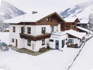a house in the snow with a car parked in front at Goldberg-Aparts Berg in Seidlwinkl