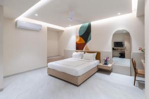 a white bedroom with a bed and a kitchen at Champion Prime-My Downtown Hotel in Udaipur +12 photos