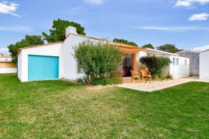 a white house with a blue garage at 700m de la plage, jardin, 4 adultes 2 enfants in Le Fier +10 photos