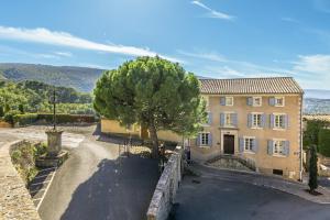 a large building with a tree in front of it at Le Major in Cadenet
