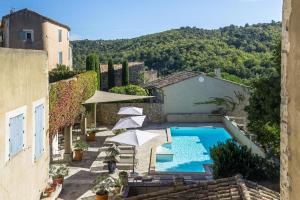 an outdoor swimming pool with umbrellas and a pool at Le Major in Cadenet +10 photos
