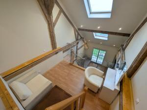 eine Aussicht über ein Wohnzimmer mit einem Sofa und einem Stuhl in der Unterkunft Duplex dans grande ferme rénovée in Divonne-les-Bains