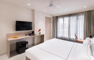 a hotel room with a bed and a television at Champion Prime-My Downtown Hotel in Udaipur