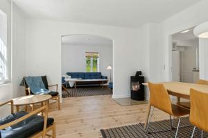 a living room with a table and chairs and a couch at Old Local House From 1904 With Natural Garden in Tranekær