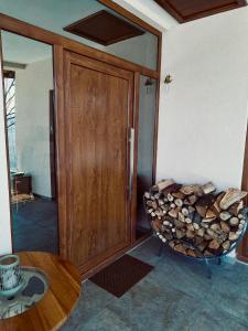 a room with a wooden door and a pile of fire wood at Slatinska idila - kuća sa bazenom in Bunar