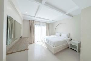 a white bedroom with a bed and a window at Mabaat-Jasmine Greek Villa 4BR- 583 Villa 3 in Jeddah +19 photos