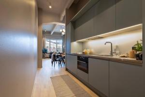 una cucina con armadi grigi e una sala da pranzo di Unity Tampere - A Studio Hotel a Tampere