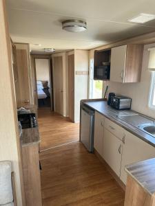 a kitchen with a sink and a counter top at Caravan by the Sea 641 in Kinmel Bay +3 photos