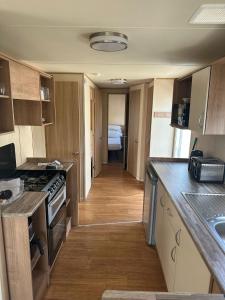 a kitchen with a stove and a hallway with a room at Caravan by the Sea 641 in Kinmel Bay