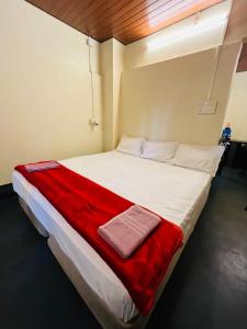 a bedroom with a large white bed with a red blanket at Siilver Sands Hutt Homestay - Malpe Beach in Malpe