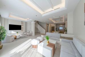 a living room with white furniture and a flat screen tv at Mabaat-Jasmine Greek Villa 4BR- 583 Villa 5 in Jeddah