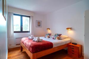 a bedroom with a bed with two pillows and a window at Ciel Etoilé - Proche de la mer in Locmariaquer