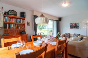 a dining room with a table and a couch at Ciel Etoilé - Proche de la mer in Locmariaquer