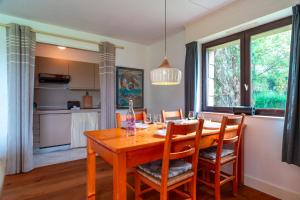 a dining room with a wooden table and chairs at Ciel Etoilé - Proche de la mer in Locmariaquer +7 photos