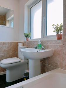 Un baño con lavabo, inodoro y espejo. en Modern 3 Bed house with parking - Chorley near M61, en Heapey 34 fotos más