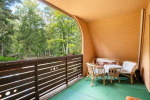 a balcony with a table and chairs and a window at Ferienwohnung - Finnhütte in Quitzdorf