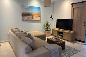 ein Wohnzimmer mit Couch und Flachbildfernseher in der Unterkunft Cottage - Sleeps 4 - Pet friendly - Pool - Parking in Johannesburg