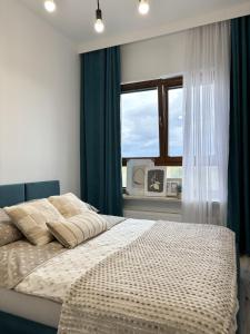 1 dormitorio con 1 cama con cortinas azules y ventana en Wilanów Residence - Two-Room Apartment, en Varsovia