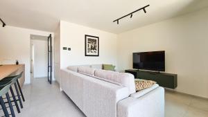 a living room with a couch and a flat screen tv at Appartement Porte Bonheur in Rochefort +5 photos