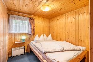 una camera da letto con un letto in una stanza di legno di Bungalow 12 - Finnhütte a Quitzdorf