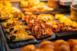 a tray of food with pastries on a table at Casa Alhaja by Shiadu in Seville +44 photos