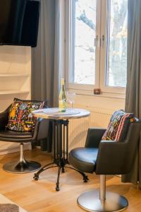 a table with two chairs and a bottle and a glass at Haga Studio, Super Location with Full Comfort in Gothenburg