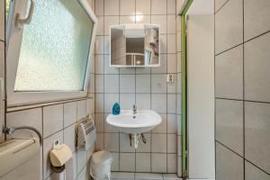 un piccolo bagno con lavandino e specchio di Bungalow 15 - Finnhütte a Quitzdorf Altre 11 foto