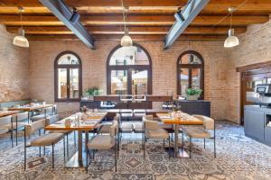 a dining room with tables and chairs and brick walls at Eurostars Residenza Cannaregio in Venice