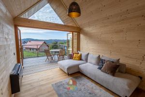 a living room with a couch and a patio at Orfű Skandináv Kabin in Orfű