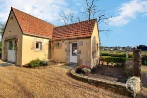 een klein geel huis met een rood dak bij La maison de la plage in Trégastel
