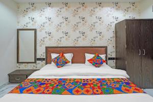 a bedroom with a large bed with a colorful comforter at FabHotel Aurika Retreat in Indore