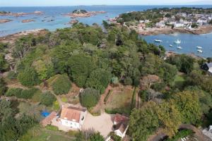 an aerial view of a house on an island in the water at La maison de la plage à 6 in Trégastel
