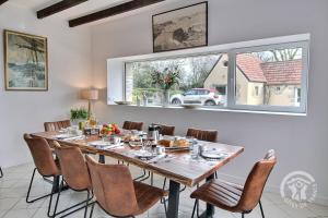 a dining room with a table and chairs and a window at La maison de la plage à 6 in Trégastel