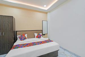 a bedroom with a bed with colorful pillows at FabHotel Aurika Retreat in Indore +23 photos