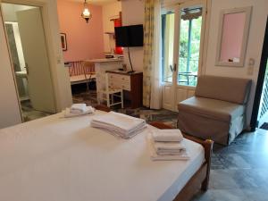 a room with a bed and a chair with towels on it at Grivas Apartments in Sivota