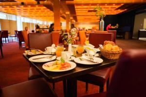 a table with plates of food and a basket of bread at Bettenburg Hotel in Hamburg +16 photos