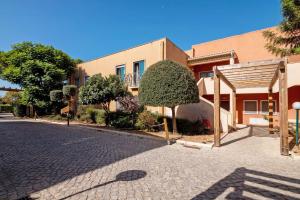 a building with a tree next to a street at Do Vale Hollidays in Galé