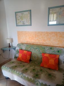 a couch with two colorful pillows on it at Casa Michelangelo in Lecchi di Staggia