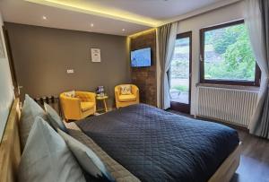 a bedroom with a large bed and two yellow chairs at Das Waldhaus - Winter Boardinghaus in Forbach