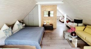 a bedroom with a bed and a couch in a room at Das Waldhaus - Winter Boardinghaus in Forbach