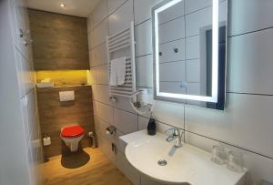 a bathroom with a sink and a red stool at Das Waldhaus - Winter Boardinghaus in Forbach